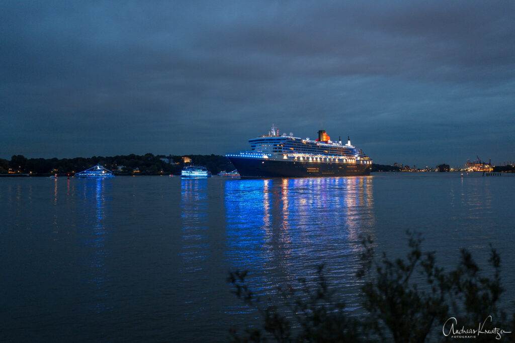 Queen Mary 2 in Blue Port Beleuchtung mit Begleitschiffen