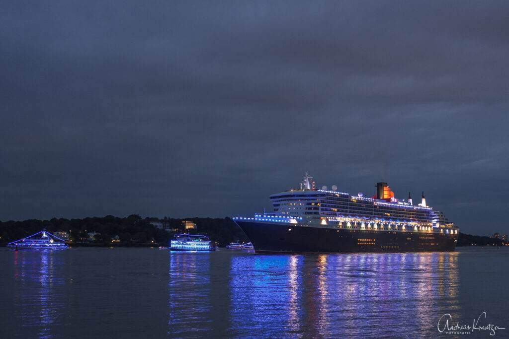Queen Mary 2 in Blue Port Beleuchtung mit Begleitschiffen